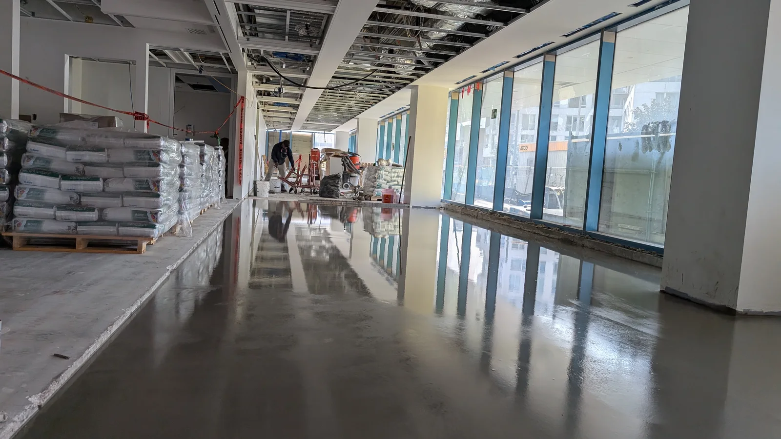 Plancher commercial gris fraîchement revêtu dans un espace institutionnel en chantier